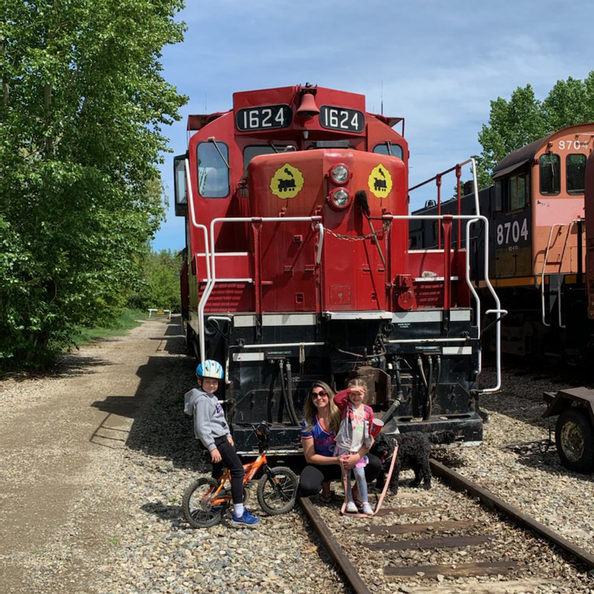Jo and the kids at Aspen Crossing, standing in front of a train